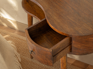 Close-up of curved wooden console table with open drawer showing dovetail detail