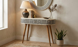 Mid century modern console table in an entryway with mirror and decorative objects