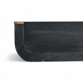 Close-up side view of a black wooden floating shelf featuring a curved edge and brass-accented corner, highlighting the smooth finish and elegant craftsmanship.
