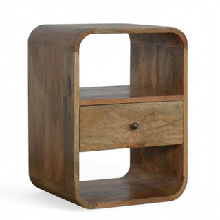 Angled view of the mango wood nightstand showcasing its smooth curved design and open shelf.