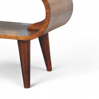 Close-up of the coffee table's curved frame, highlighting the craftsmanship and natural wood grain texture. 

