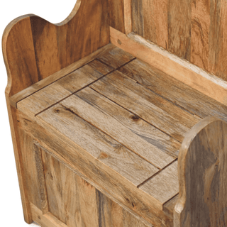 Close-up of the planked natural mango wood seat and panelled backrest of a settle bench