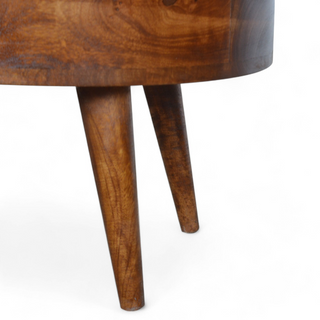 Close-up view of the tapered wooden legs of the oval coffee table, showcasing their sturdy construction and elegant design.
