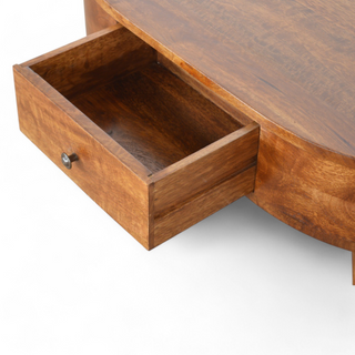 View of the oval wooden coffee table with the central drawer open, revealing ample storage space for small items.