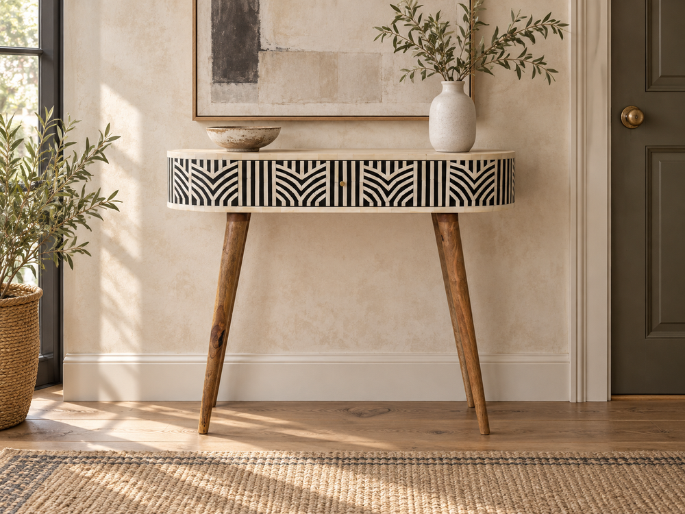 Decorative wooden console table with geometric drawer fronts and tapered legs against a softly textured wall.