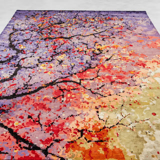 A square area rug with an abstract, pixelated tree branch pattern in a multicolor palette of purple, red, orange, yellow, and beige.
