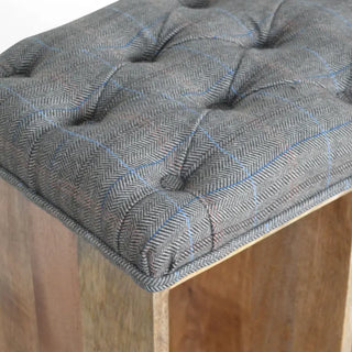 Detailed view of the deep-buttoned grey tweed tufted seat cushion on a mango wood storage bench