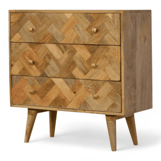 Angled left view of the chest highlighting its patterned drawers, brass knobs, and smooth wooden finish.
