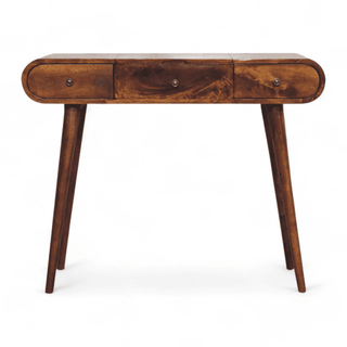 Front view of a vintage dressing table in dark mango wood with mid-century modern rounded edges, three drawers, and tapered legs.
