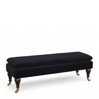 Angled view of Black Velvet Upholstered Bench with Castor Legs, showing the upholstered seat, legs and silhouette