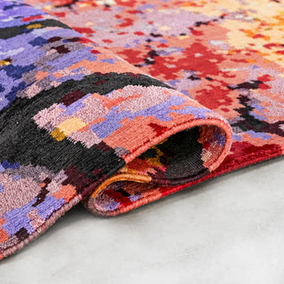 Bloomscape hand-knotted rug with curled corner showing colourful wool and silk texture and finished edge