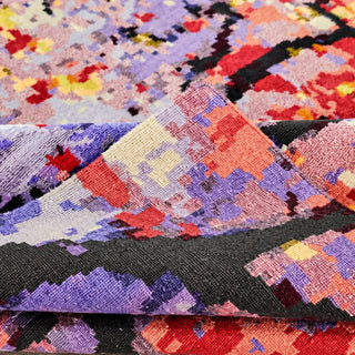 Folded Bloomscape abstract rug showing intricate purple, coral and red woven detailing with dark branching patterns