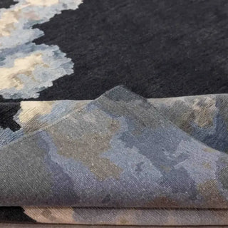 Folded edge of an abstract rug showing the carved pile between navy and pale blue