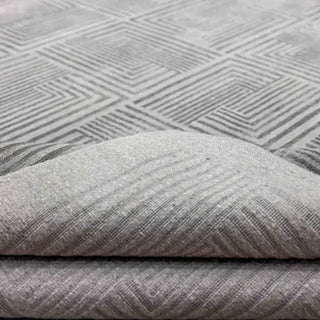 Folded grey rug corner showing fine linear pattern and gentle silk sheen