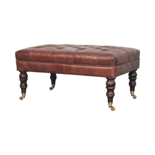 Side angle view of Harlow Ottoman Bench Chestnut Brown Buffalo Leather Hand-Tufted Brass Castor Legs