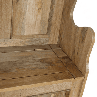 Close-up of the mango wood seat, lid hinge, and panelled backrest of a monk's bench