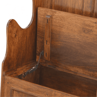 Close-up of a wooden storage bench or bed frame with a lift-up back panel and metal support hardware, shown on a plain white background.