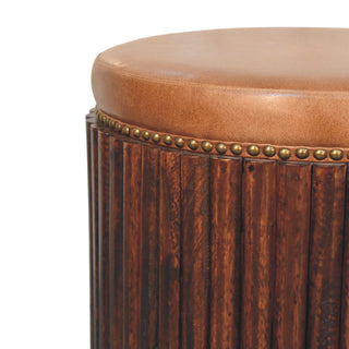 Ribbed leather accent stool side view left showing compact form and wooden legs